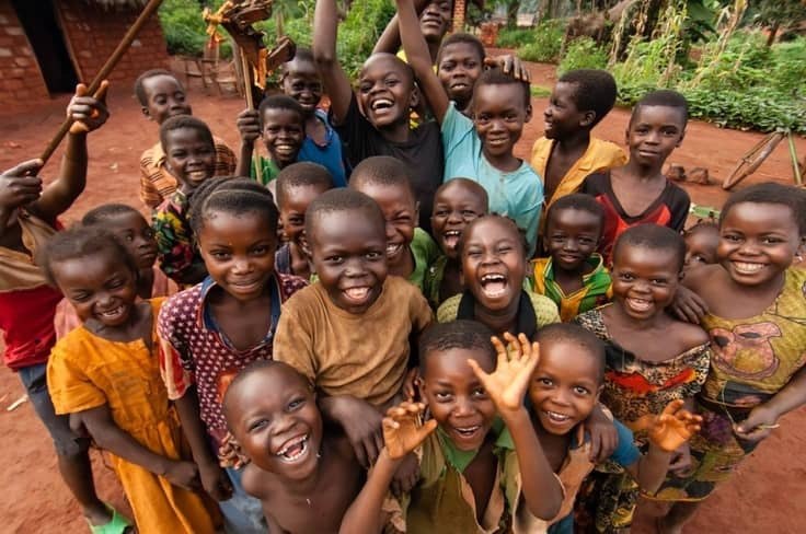 A large group of children laughing together outdoors