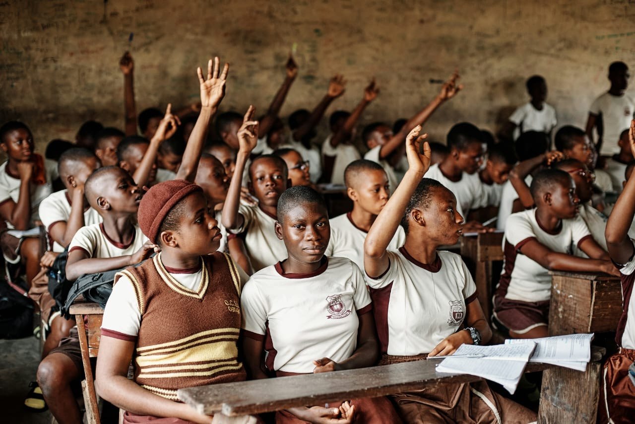 Students raising their hands in a classroom